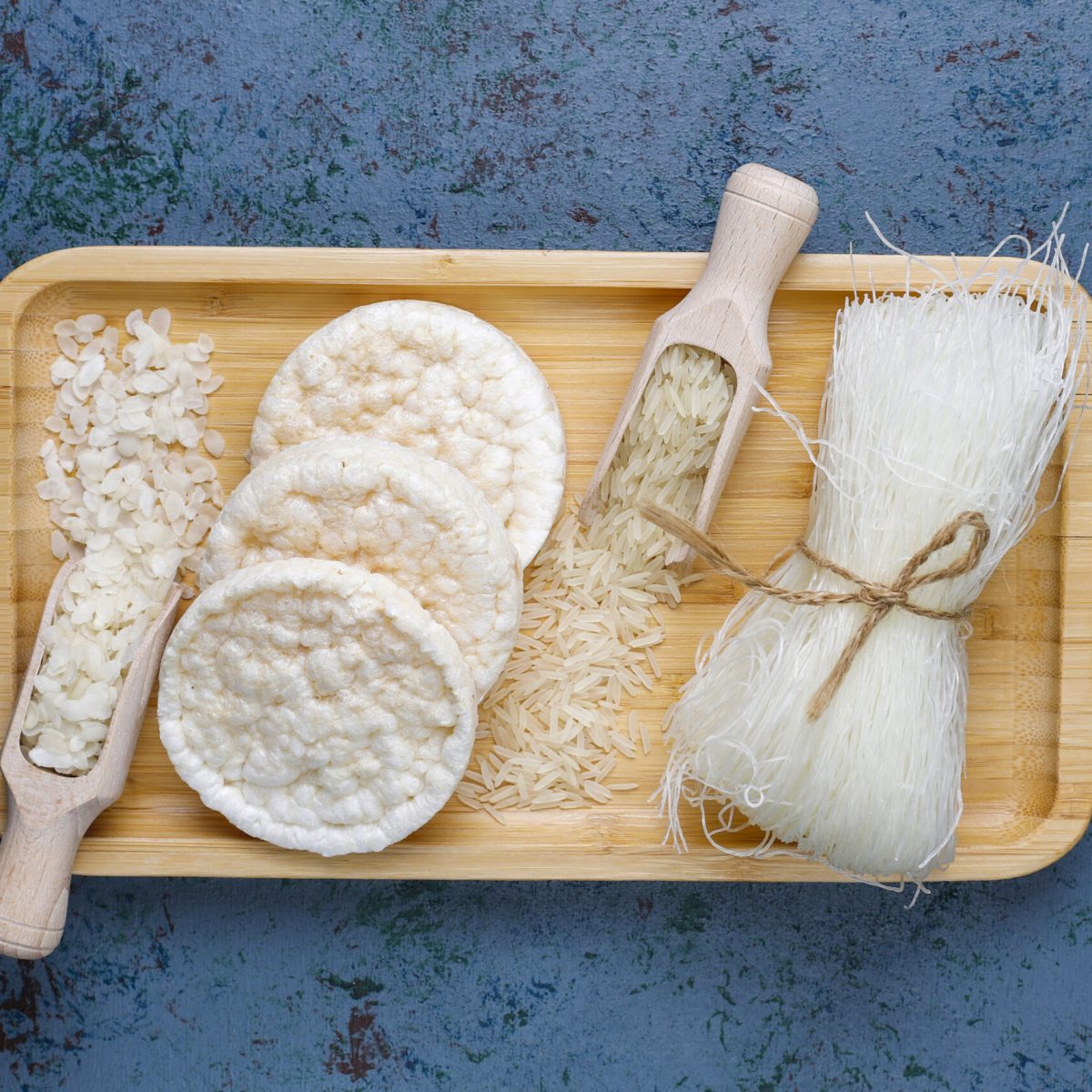 Rice flakes,rice noodles,rice bread and rice on dark background,top view